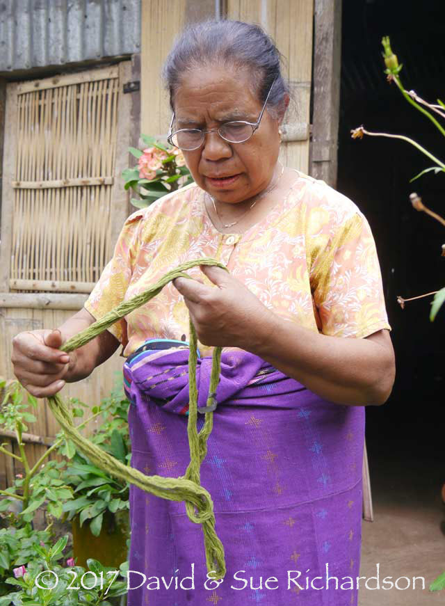 Description: Alberta Jaga Watun at her home in Lerek with a skein of her green dyed cotton