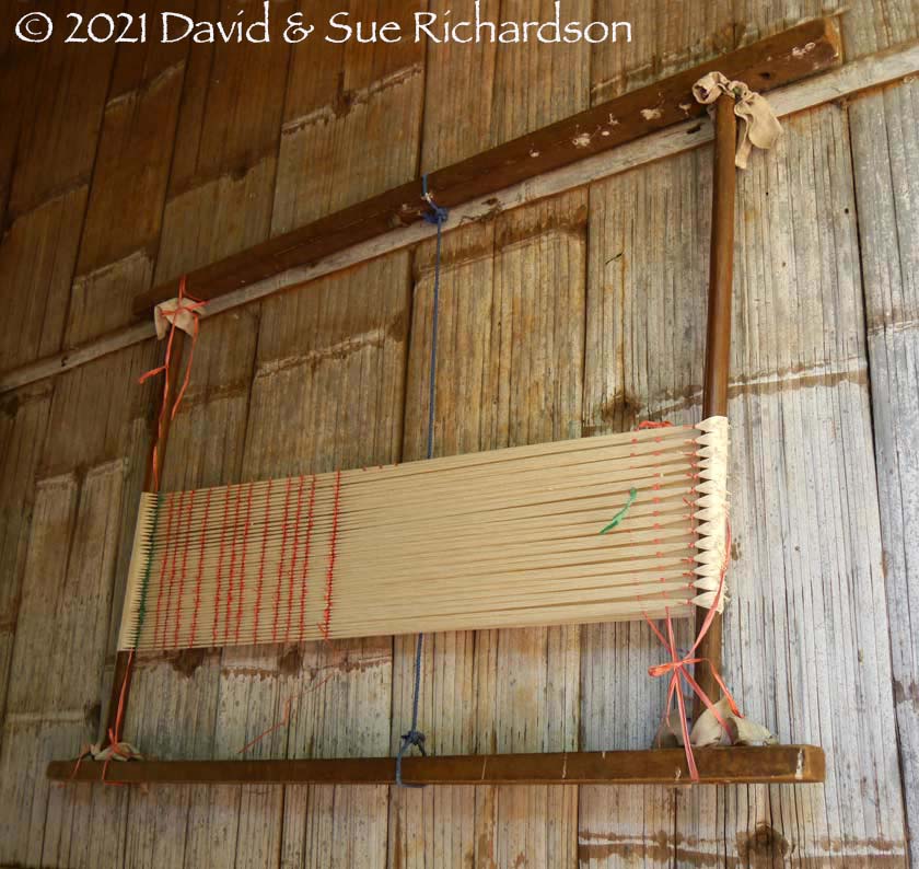 Description: An ikat binding frame hung on the side of a house in Titihena