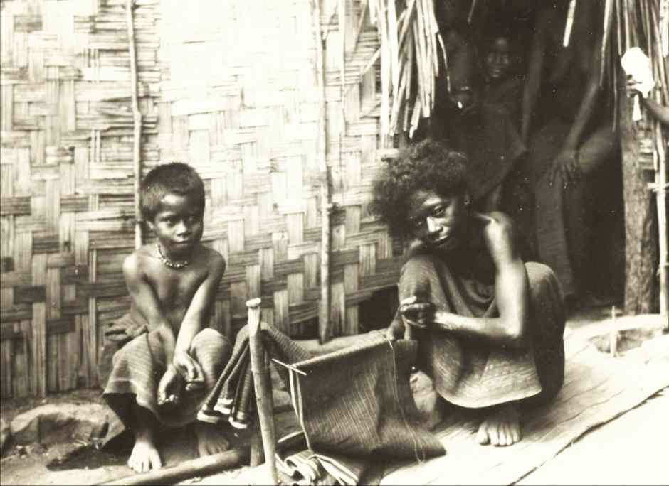 Description: A mother wearing a ragged plain woven tube skirt